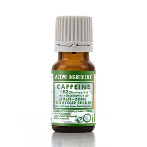 A small amber glass bottle of eOil Caffeine + B3 Multi-Zone Contour Serum with a white ribbed cap and a green and white label, set against a plain white background with a soft reflection.