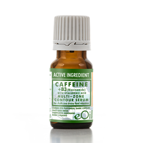A small amber glass bottle of eOil Caffeine + B3 Multi-Zone Contour Serum with a white ribbed cap and a green and white label, set against a plain white background with a soft reflection.