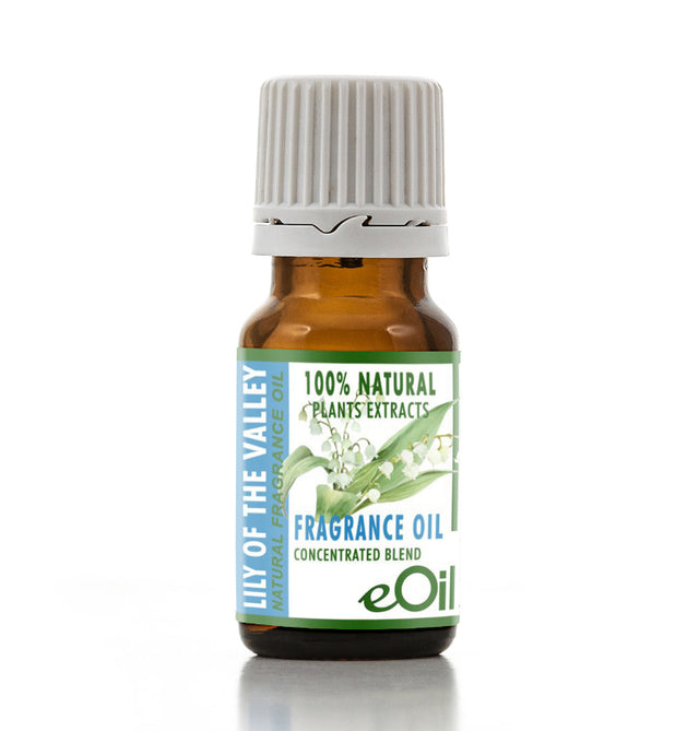 A small amber glass bottle of Lily of the Valley fragrance oil with a white ribbed cap and a green and white label, shown on a white background with a soft reflection.