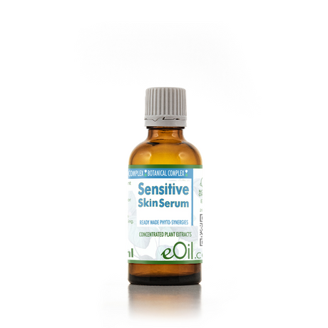 eOil Complex Sensitive Skin Serum in an amber glass bottle with a gray ribbed cap and a white label with blue and green text, set against a plain white background.
